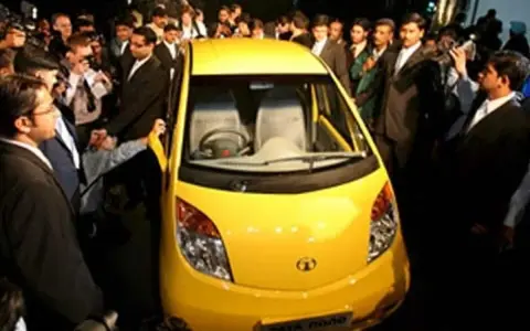En gul Tata Nano visas upp för en folkmassa.