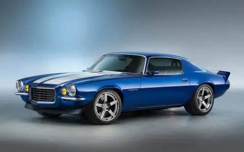 Blå Camaro 1970 med vita ränder, kromade fälgar och en sportig spoiler. En ikonisk muskelbil redo för vägen.