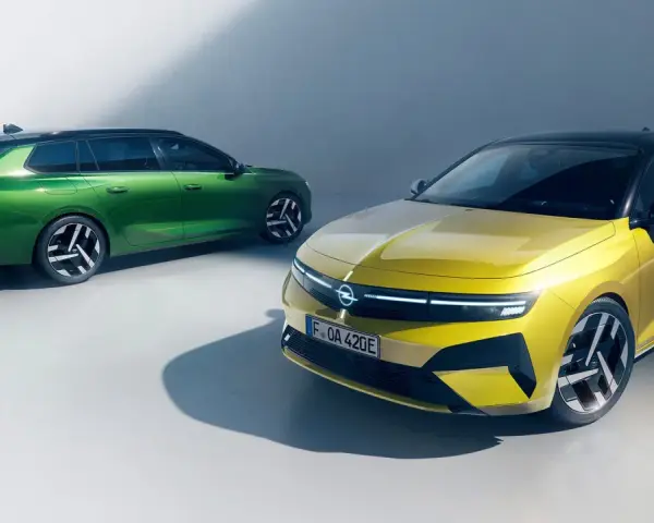 Två Opel Astra Sports Tourer, en grön och en gul, står bredvid varandra. Inga problem här, bara stil.