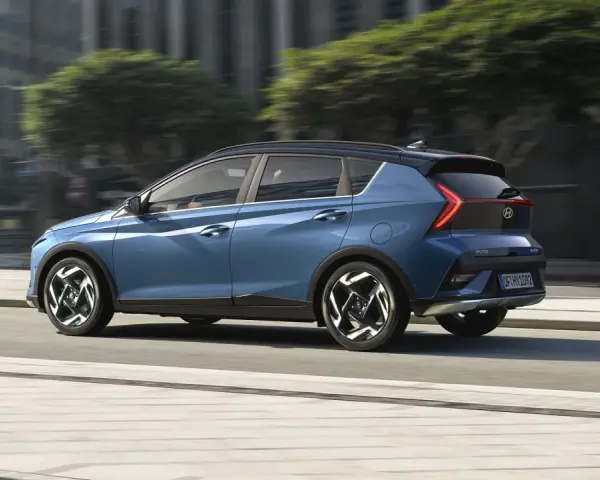Blå Hyundai Bayon körs på en stadsgata, en perfekt bild för ett hyundai bayon test.