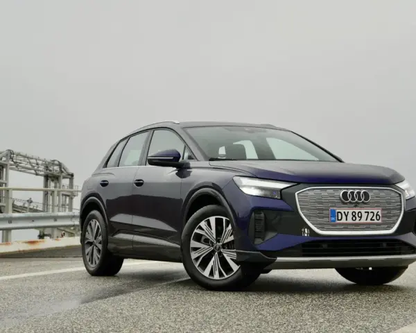 Mörkblå Audi Q4 e-tron på en väg med en bro i bakgrunden. En del av en audi q4 e-tron test.