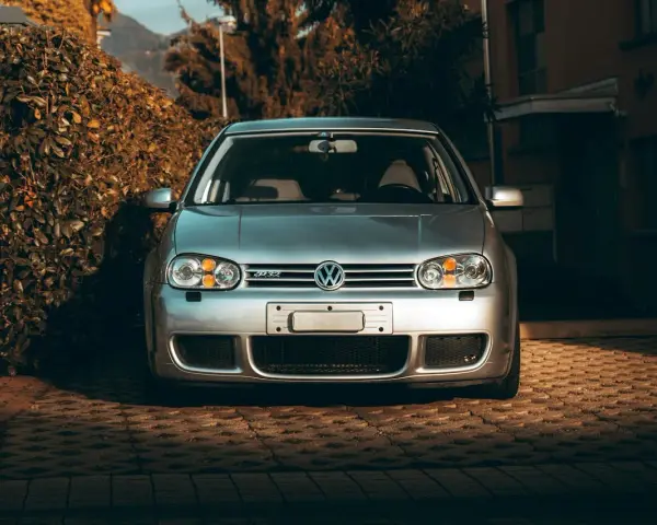 Silver VW Golf R32 framifrån. Bilen står parkerad på en stenlagd uppfart. Kanske dags att kolla styrled glapp?