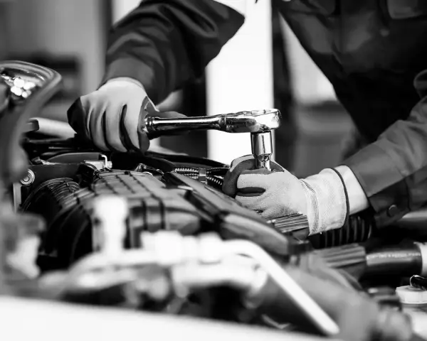 Mekaniker utför kamremsbyte på en Golf. Regelbundet kamremsbyte är viktigt för att följa serviceintervall och undvika dyra motorproblem.