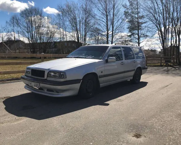Silver Volvo 940 kombi, en klassiker med en pålitlig tomgångsmotor, parkerad utomhus en solig dag.