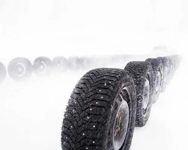 Vinterdäck i rad, redo för gislaved nordfrost 200 test i snöstorm. En bil skymtar i fjärran.