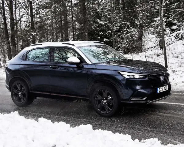 Mörkblå Honda HR-V i ett snöigt skogsparti, redo för ett vintertest.
