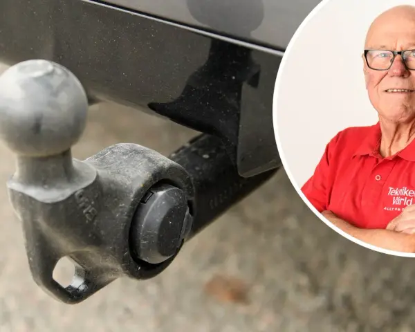 En man i röd tröja med texten "Tekniker Värld" ler, bredvid en bil med dragkrok. Dags att ta bort dragkrok?