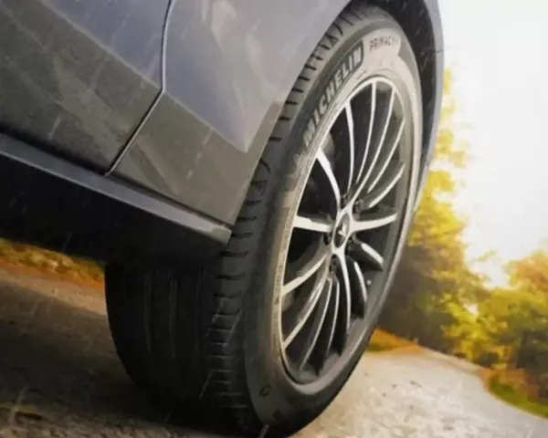 Michelin Primacy 4-däcket på en bil som kör på en väg i soligt höstväder.