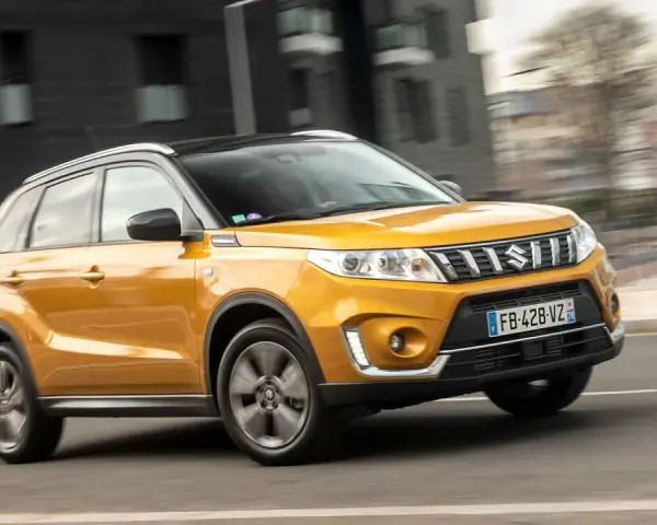 Gul Suzuki Grand Vitara körs på en stadsgata. Kanske ett problem med bilen som gör att den körs i hög fart?