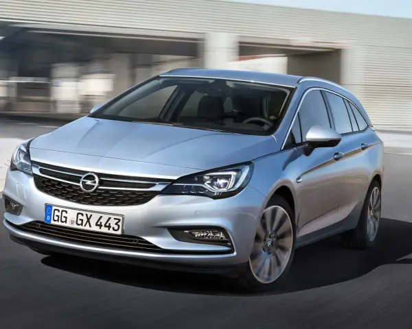Silver Opel Astra kombi körs på en väg. En bra bil för familjen, perfekt för ett opel astra begagnad test.