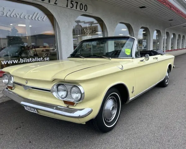 Gul cabriolet Chevrolet Corvair från 1960-talet parkerad utanför Bilstallet.