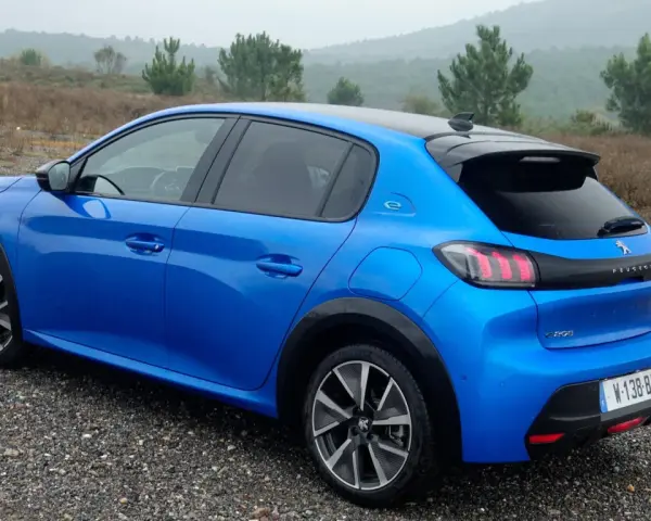 Blå Peugeot e-208 GT på grusväg. En elbil redo för peugeot e-208 test i naturen.