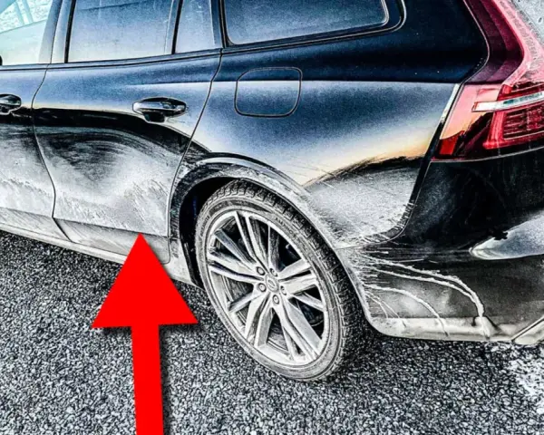 En mörk bil täckt av frost och smuts. En röd pil pekar mot en rostig bil.