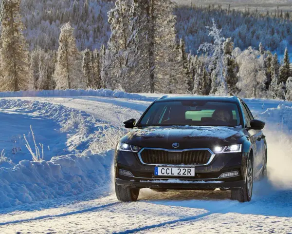 Skoda Octavia IV problem: bilen kör på en snöig väg i Sverige, omgiven av frostiga träd.