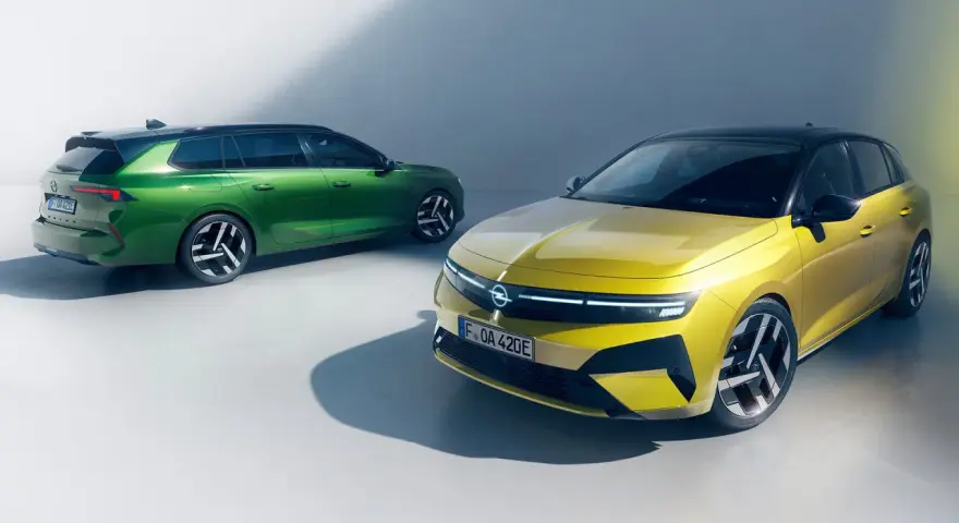 Två Opel Astra Sports Tourer, en grön och en gul, står bredvid varandra. Inga problem här, bara stil.