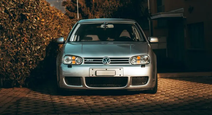 Silver VW Golf R32 framifrån. Bilen står parkerad på en stenlagd uppfart. Kanske dags att kolla styrled glapp?