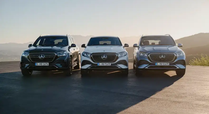 Tre Mercedes-elbilar står uppradade i solnedgången. En mörk, en vit och en blågrå. Perfekt för service.