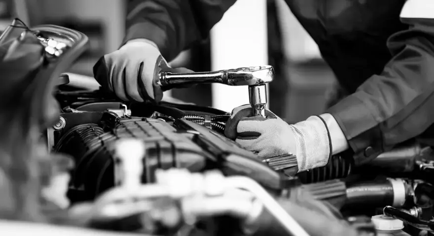 Mekaniker utför kamremsbyte på en Golf. Regelbundet kamremsbyte är viktigt för att följa serviceintervall och undvika dyra motorproblem.