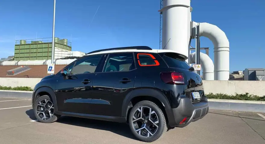 Svart Citroën C3, parkerad vid industribyggnad. Kanske ett problem med bilen?