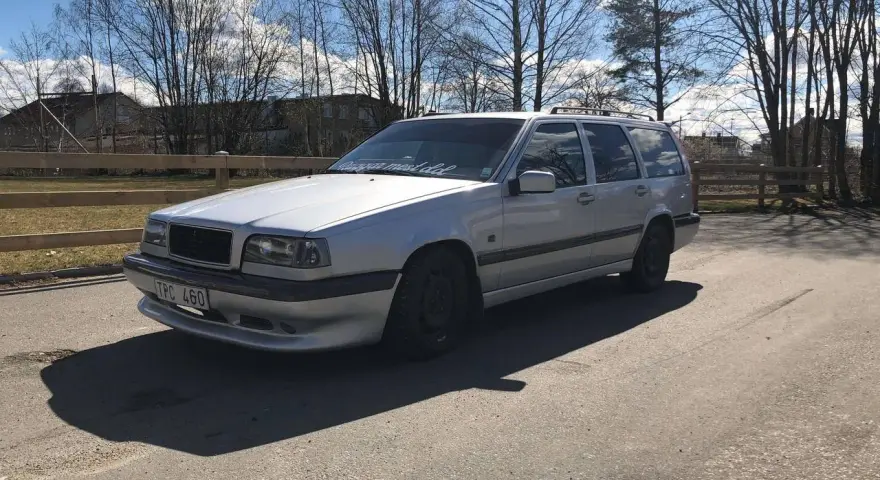 Silver Volvo 940 kombi, en klassiker med en pålitlig tomgångsmotor, parkerad utomhus en solig dag.