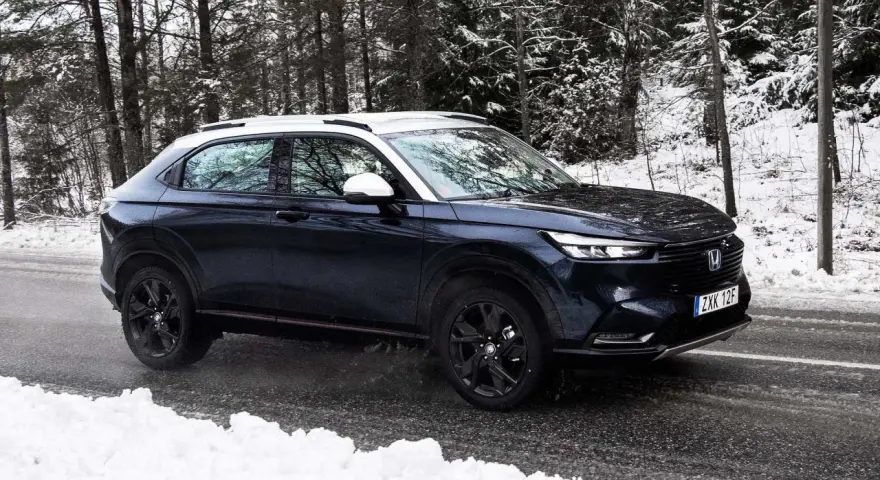 Mörkblå Honda HR-V i ett snöigt skogsparti, redo för ett vintertest.