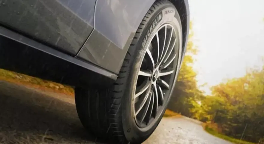Michelin Primacy 4-däcket på en bil som kör på en väg i soligt höstväder.