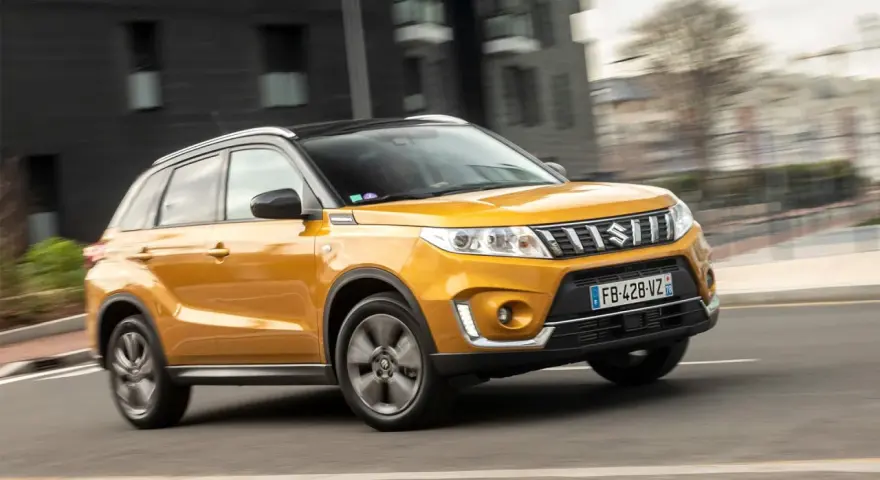 Gul Suzuki Grand Vitara körs på en stadsgata. Kanske ett problem med bilen som gör att den körs i hög fart?