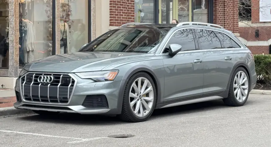Grå Audi A6 Allroad parkerad utanför en butik. Kanske ett audi a6 allroad problem med parkeringen?
