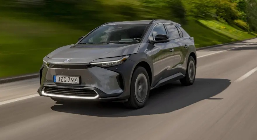 Grå Toyota bZ4X kör på en landsväg. Trots att det är en elbil, finns det ett känt toyota bz4x problem med hjulen.