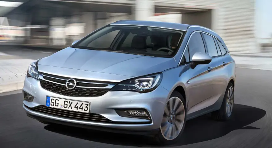 Silver Opel Astra kombi körs på en väg. En bra bil för familjen, perfekt för ett opel astra begagnad test.