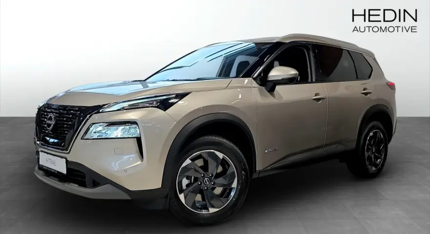 A tan Nissan X-Trail e-POWER SUV is shown from the front three-quarter view in a showroom.