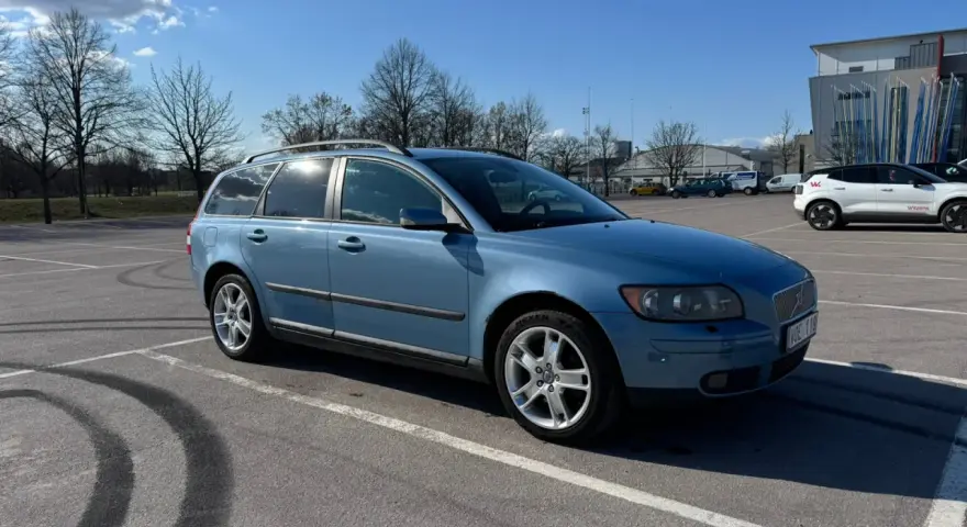 Blå Volvo V50 parkerad på en parkering. Dags att byta hjullager på V50:n.