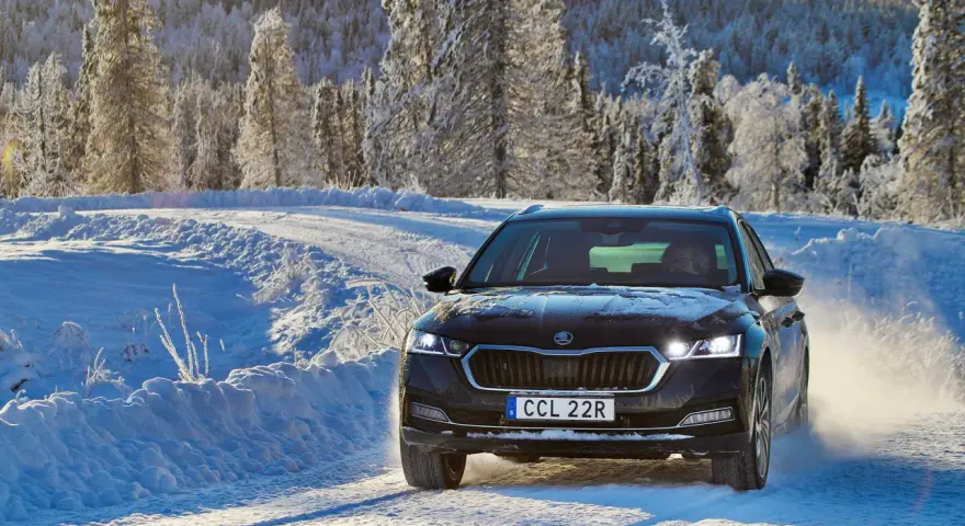 Skoda Octavia IV problem: bilen kör på en snöig väg i Sverige, omgiven av frostiga träd.