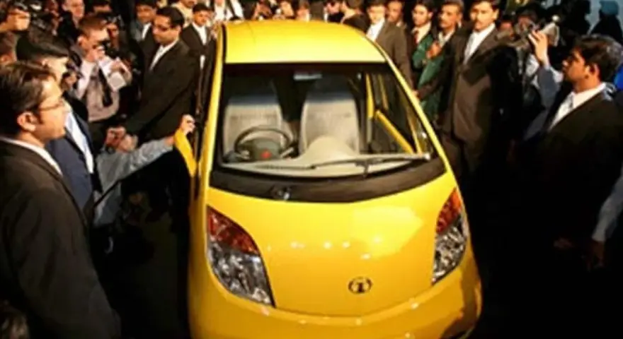 En gul Tata Nano visas upp för en folkmassa.