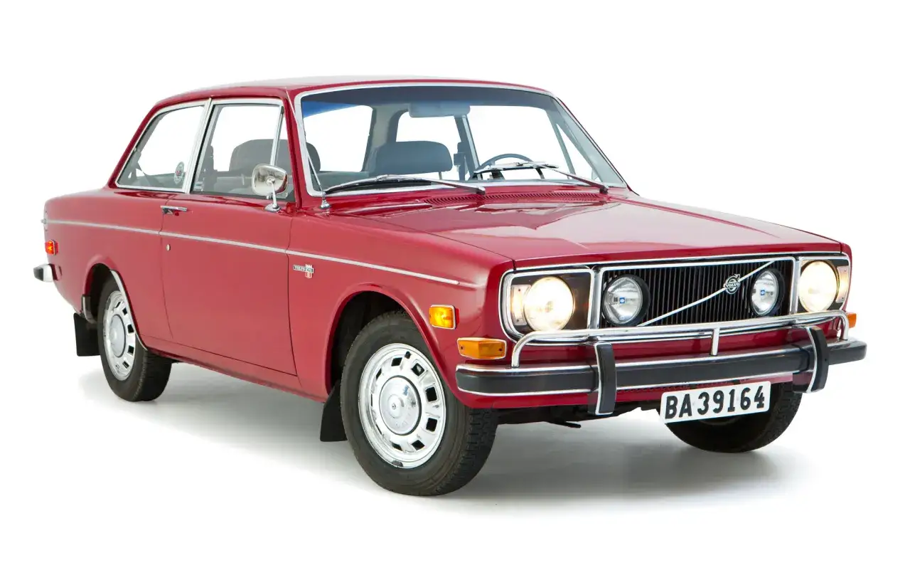 R&ouml;d, gammal Volvo 142 GL fr&aring;n 1973 med kromdetaljer och klassiska f&auml;lgar. En tidl&ouml;s svensk klassiker.