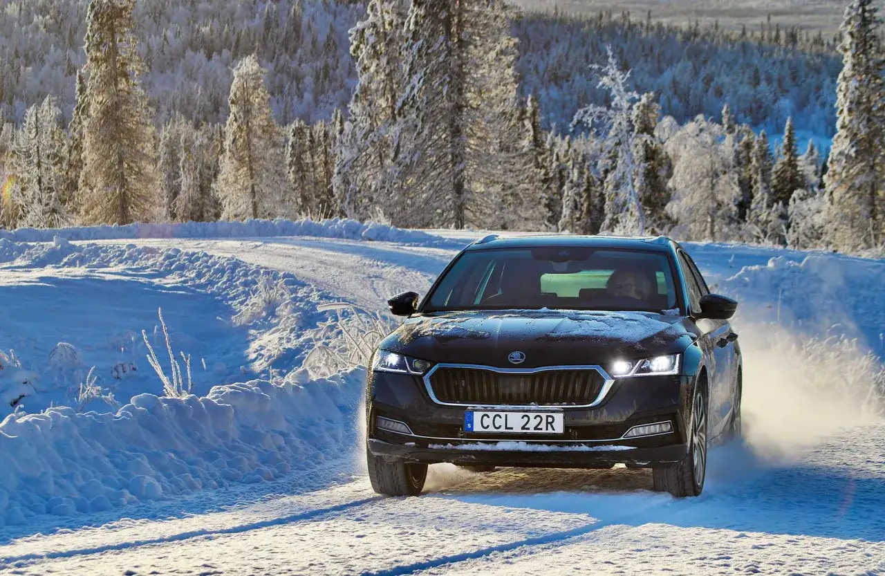 Skoda Octavia IV problem: bilen k&ouml;r p&aring; en sn&ouml;ig v&auml;g i Sverige, omgiven av frostiga tr&auml;d.
