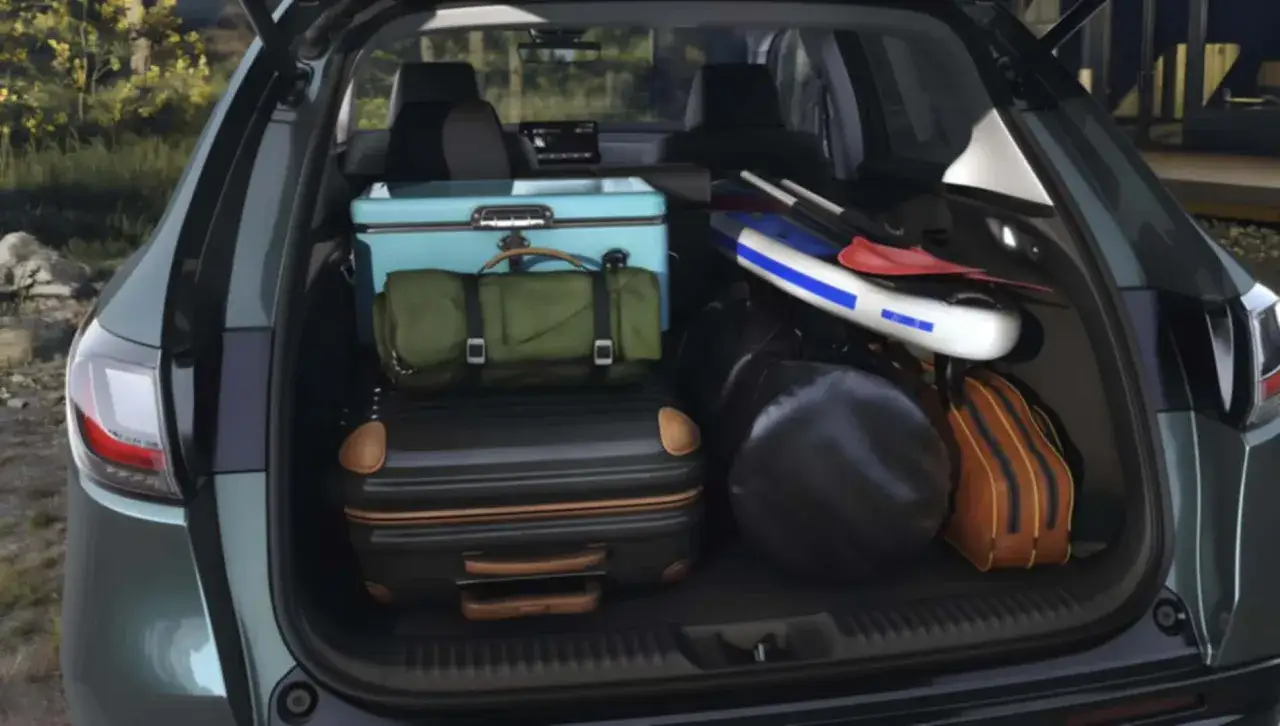 Bagage packat i en Honda HR-V för en testresa. En kylbox, sovsäck, resväskor och paddlar redo för äventyr.