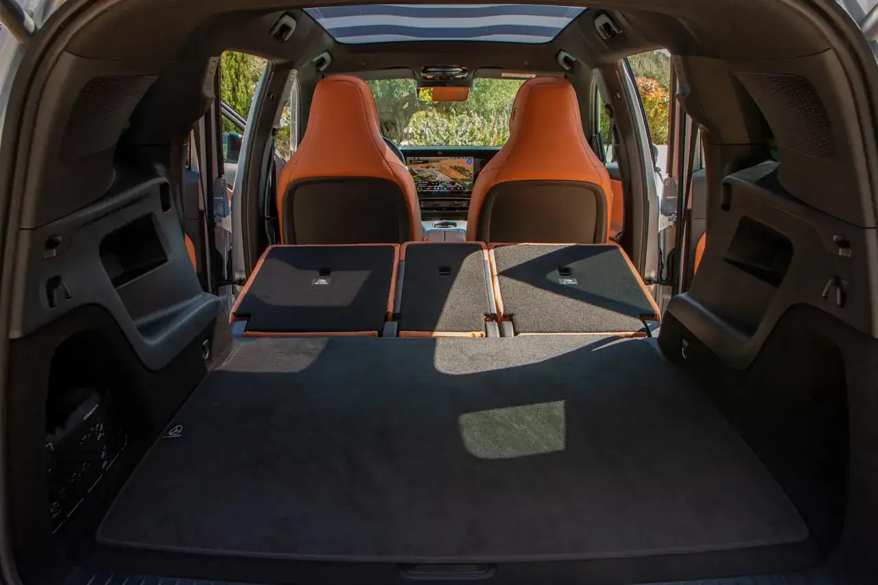 Bagageutrymmet i en Mercedes GLB testbil med fällda baksäten och orangea lädersäten framtill.