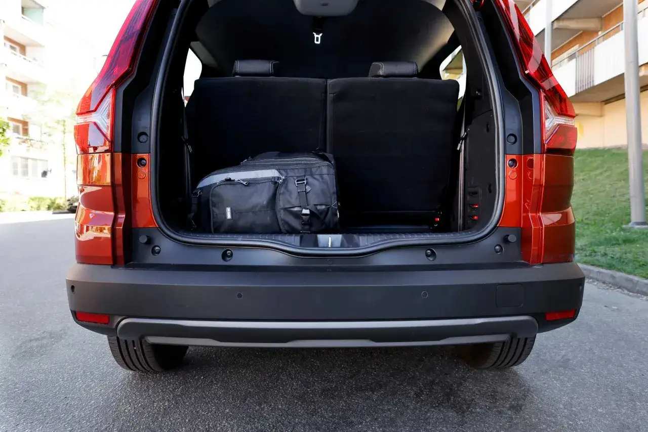 Bagageutrymmet i en Dacia Jogger testbil. En svart v&auml;ska ligger p&aring; golvet bakom nedf&auml;llda s&auml;ten.