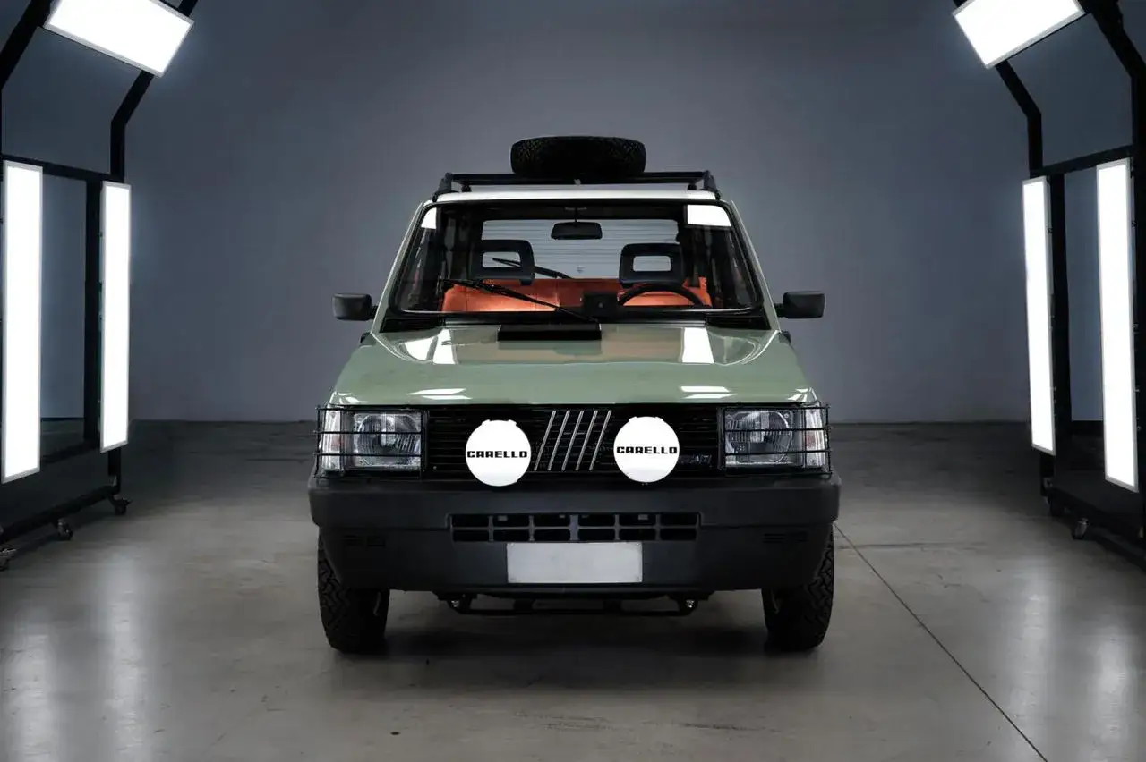 Gr&ouml;n Fiat Panda fr&aring;n 1980 med terr&auml;ngmodifieringar, takr&auml;cke med reservhjul och extraljus.