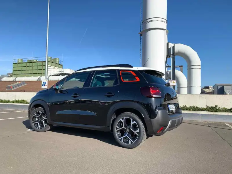 Svart Citroën C3, parkerad vid industribyggnad. Kanske ett problem med bilen?