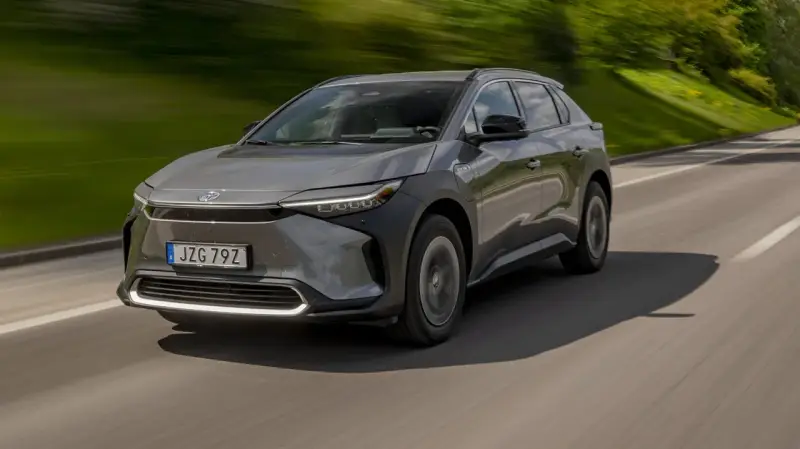 Grå Toyota bZ4X kör på en landsväg. Trots att det är en elbil, finns det ett känt toyota bz4x problem med hjulen.